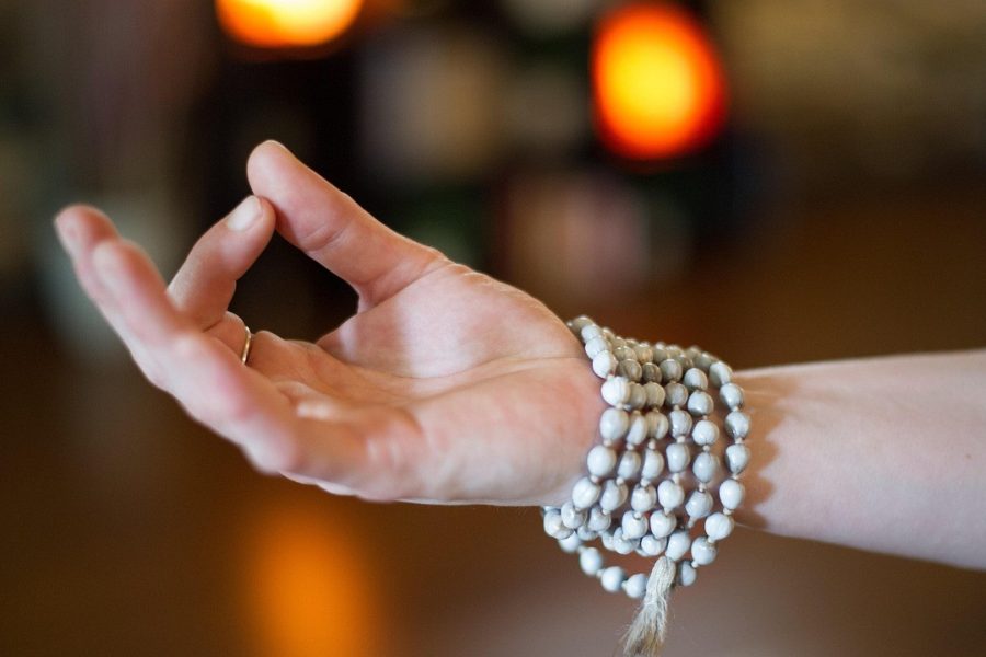 Mano in posizione di meditazione durante una lezione di yoga