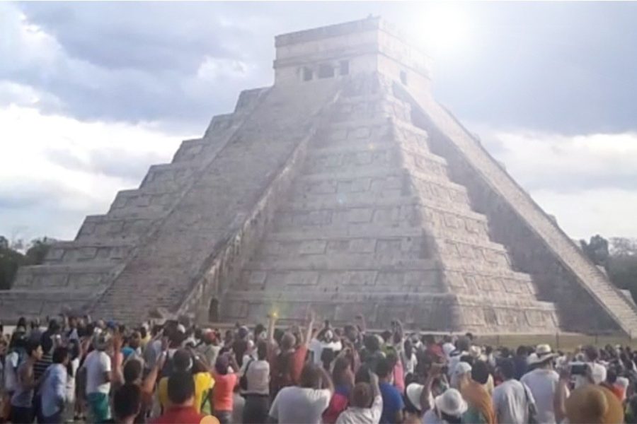 Una piramide maya con una folla ai suoi piedi
